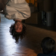 Ben Schnetzer's Yorick Brown hangs upside-down in a magician's straightjacket while a small child watches him in Y: The Last Man.